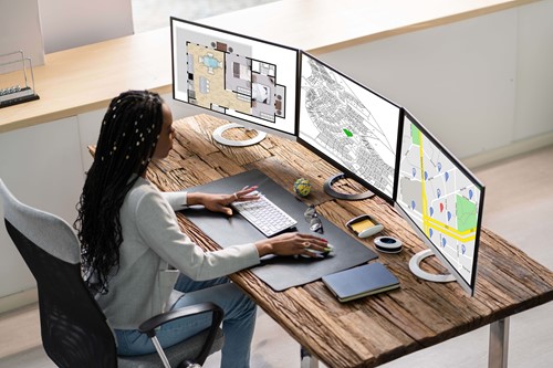women at computer looking at plot of land 