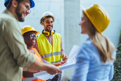 workers in hard hats laughing and smiling 